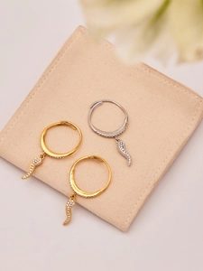 Detail of three adjustable gold and silver rings with cubic zirconia charms on velvet