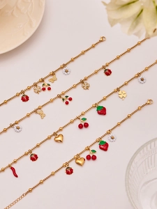 Detailed shot of gold ball chain bracelets featuring colorful enamel fruit and insect charms