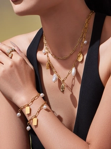 Detail of gold-plated stainless steel jewelry set with baroque pearls and pendants