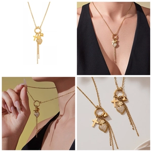 Detailansicht der goldenen Kette mit Kreuz, Zirkonia-Herz und langen Metall-Quasten