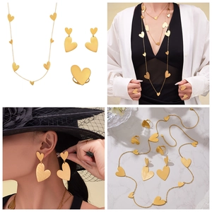 Detailed four-piece jewelry set with matte gold heart necklace, earrings, and wide ring