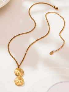 Detail of gold spiral disc pendant on a vintage link chain with adjustable lobster clasp