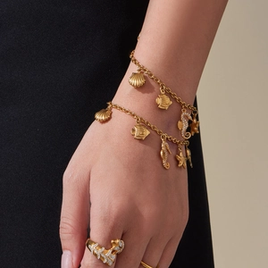 Bracciale dorato con ciondoli marini e stelle marine e un anello di zirconi