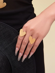 Macro detail of gold-plated stainless steel heart rings with elegant brushed finish