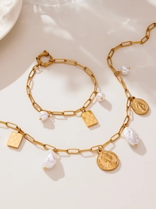 Detail of gold necklace and bracelet set with baroque pearls and relief coin charms