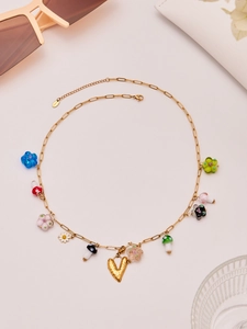 Detail of colorful resin flower and mushroom pendants on a gold stainless steel chain