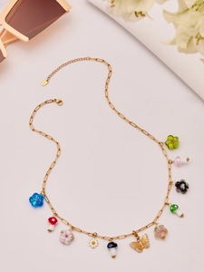 Detail of stainless steel necklace with colorful mushroom and butterfly charms on white background
