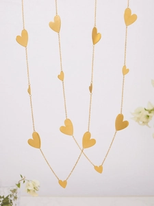 Close-up of gold heart pendant long sweater necklace with brushed texture finish