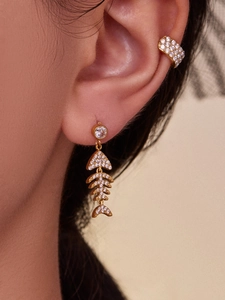 Vue détaillée des boucles d'oreilles arête de poisson plaquées or 18k avec zircons