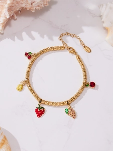 Close-up of gold-plated stainless steel bead bracelet with colorful fruit charms and rhinestones