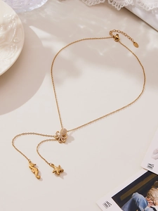 Detail of gold octopus Y-necklace with cubic zirconia, seahorse and starfish charms