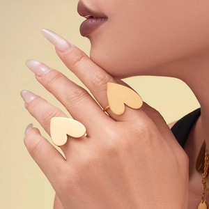 Chunky 18k gold plated heart rings set on hand with a polished minimalist aesthetic