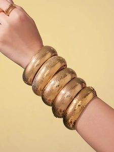 Dettaglio di 5 bracciali in acciaio inossidabile placcato oro 18k con texture serpente e martellata