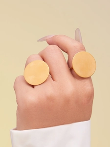 Close-up van minimalistische gouden ronde platte ringen met een gladde satijnen finish