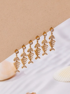 Détail de boucles d'oreilles squelette de poisson en zircon et plaqué or 18 carats
