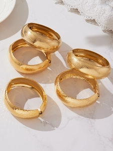 Dettaglio di bracciali in acciaio inossidabile placcato oro 18k con diverse texture