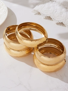 Dettaglio di bracciali in acciaio inossidabile placcato oro 18k con texture martellate