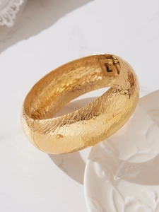 Vista macro del bracciale in acciaio inossidabile placcato oro 18k con trama martellata