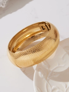 Dettaglio macro del bracciale in acciaio placcato oro 18k con trama a nido d'ape