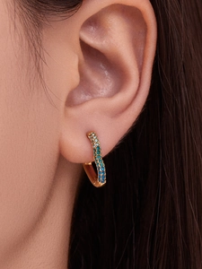 Macro shot of 18k gold plated hoop earring featuring gradient blue zircon pavé setting