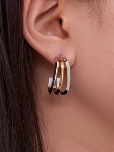 Dettaglio orecchini a cuore a tre strati a forma di U in oro 18k e finitura argento