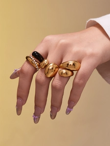 Détail de bagues goutte en acier inoxydable plaqué or 18k avec fini poli sur main de mannequin
