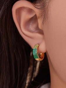 Detail of gold-plated hoop earrings featuring micro-set gradient green cubic zirconia