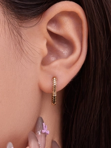 Macro shot of gold ear cuff featuring contrast clear and black pavé-set zircons