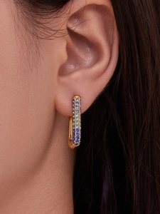 Detailed view of U-shaped gold earrings with gradient 5A cubic zirconia pavé stones