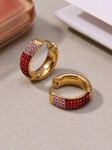 Macro view of gold hoop earrings with gradient red and pink micro-pave zircons