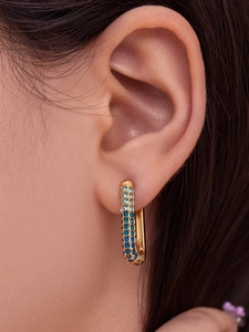 Macro shot of gold-plated U-shaped earrings with blue gradient 5A zircon stones