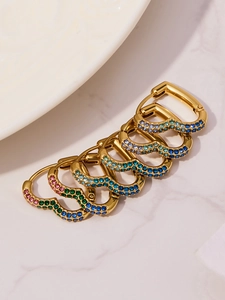 Macro shot of 18k gold plated heart huggie earrings with colorful rainbow zircon stones