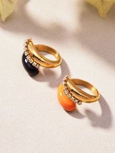 Détail de bagues double goutte plaquées or 18 carats avec pierres noires et oranges