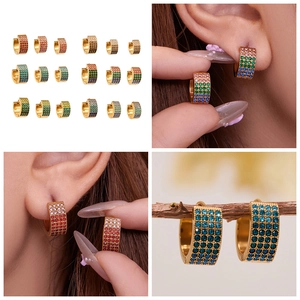Détail de créoles dorées à l'or 18k avec quatre rangées de zircons colorés sertis