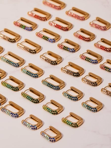 Detailed array of U-shaped gold earrings with colorful gradient cubic zirconia pavé
