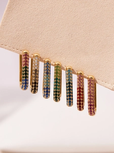 Detail showing seven pairs of U-shaped gold earrings with multicolored 5A zircons