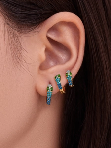 Close-up of three-piece set snake earrings with blue and green crystals in gold