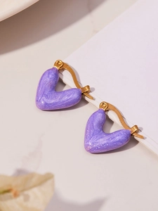 Details von lila perlmuttartigen Herzohrringen mit goldenen Creolen in Lifestyle-Optik