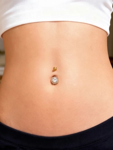 Primer plano de un piercing de ombligo de oro de 18k con brillantes circonitas 5A