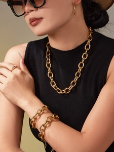 Détail d'un ensemble collier et bracelet à grosse chaîne cubaine plaqué or sur mannequin