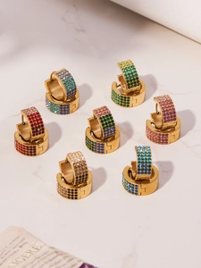 Détail de sept paires de boucles d'oreilles huggie dorées serties de zircons colorés