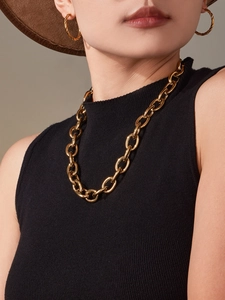 Gros plan sur le collier à maillons cubains dorés 18 carats et boucles d'oreilles torsadées