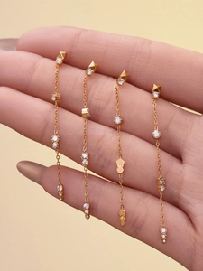 Détail de boucles d'oreilles franges plaquées or 18k avec zircons brillants en main