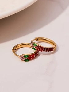 Close-up of gold U-shaped earrings with colorful red, green, and pink zirconia crystals