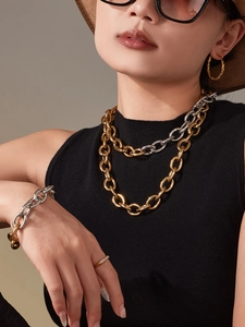 Ensemble collier et bracelet à grosse chaîne bicolore porté par un mannequin