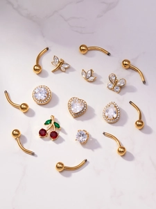 Macro detail of assorted cubic zirconia navel rings in gold over marble surface