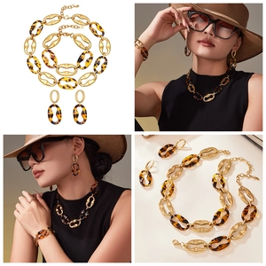 Detail of vintage gold-matte metal and tortoise resin jewelry set worn by a model