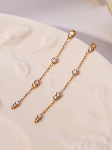 Vue détaillée de pompons en or 18k avec zircons cubiques posés sur une assiette en céramique