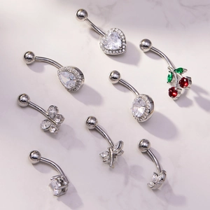 Detailed flat lay of stainless steel navel rings with heart and water drop zircons