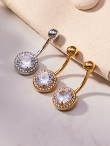 Detail of three belly rings with round zircons in gold and silver finishes